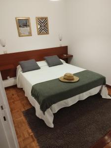 a bedroom with a large bed with a hat on it at Aconchego do Lar in Geres