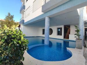 a swimming pool in front of a building at La Cascade Ḩammām al Ghazzāz in Kelibia