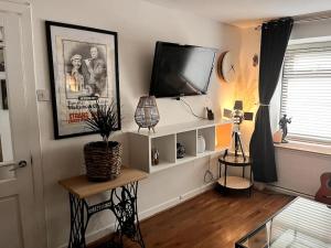 a living room with a flat screen tv on a wall at Clancy Brothers Homestead in Carrick-on-Suir