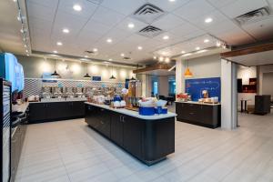 eine große Küche mit Arbeitsflächen und Waschbecken in einem Laden in der Unterkunft Holiday Inn Express & Suites Orlando- Lake Buena Vista, an IHG Hotel in Orlando