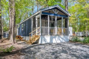 a tiny house in the woods with a porch at Sun Outdoors Cape May in Cape May