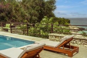 - une piscine avec 2 chaises longues et l'océan dans l'établissement Anassa Mare Villas & Residences, à Gaios