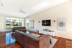 a living room with a couch and a tv at Riversea Goolwa Beach House in Goolwa