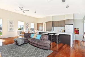 a living room with a couch and a kitchen at Riversea Goolwa Beach House in Goolwa