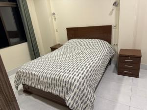 1 cama con edredón blanco y negro en un dormitorio en Apartamentos MI FAMILIA en Sucre