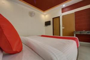 a bedroom with a white bed with red pillows at Golden Hill Resort in Santaveri