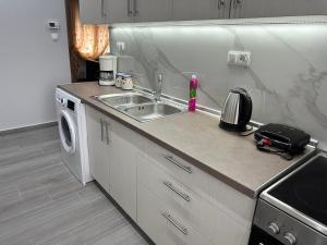 een keuken met een spoelbak en een wasmachine bij JennyHouse in Drama