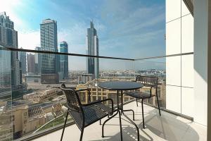 uma varanda com mesa e cadeiras e vista para a cidade em Stayis -Spacious & Luxury 1 Bedroom room Apartment em Dubai