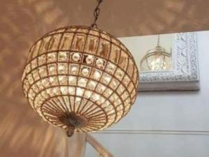 una lámpara de araña de mimbre colgada del techo con un espejo en Heritage View Guest House, en Ironbridge