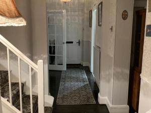 un pasillo con una puerta blanca y una escalera con una escalera en Heritage View Guest House, en Ironbridge