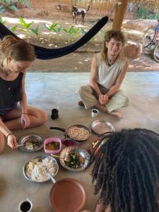 un paio di persone sedute a terra con del cibo di Chill House Hostel a Anuradhapura