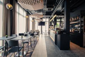 a restaurant with tables and chairs and a bar at Hota Hotel Saint-Imier in Saint-Imier