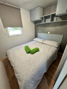 Un dormitorio con una cama con un zapato verde. en Bungalow BAMBOLERA en Torrelaguna