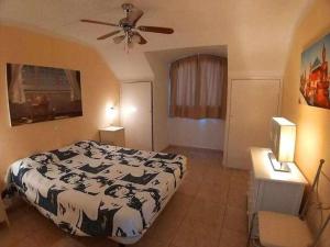 een slaapkamer met een bed en een plafondventilator bij Ático con impresionantes vistas al mar in Adeje