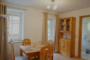 a dining room with a wooden table and chairs at Apart & Heu Hotel Hofmann in Niederaula +7 photos