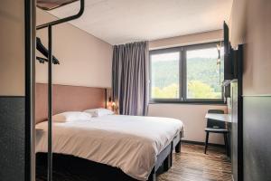une chambre d'hôtel avec un lit et une fenêtre dans l'établissement Hota Hotel Saint-Imier, à Saint-Imier