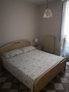 a bedroom with a bed and a lamp and a window at Casa a Scale in Sulmona