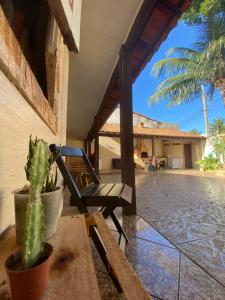 a chair on the porch of a house with a cactus at Quarto cápsula in Saquarema