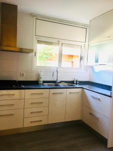 a kitchen with white cabinets and a sink and a window at Casa de Aurora in Rubí +28 photos