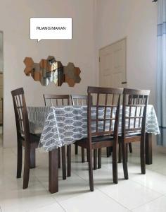 a dining room table with four chairs and a tablecloth at Farwis Homestay in Mukah
