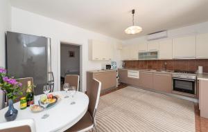 a kitchen with a white table and chairs in a room at 2 Bedroom Lovely Apartment In Potocnica in Potocnica