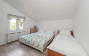 two beds in a white room with a window at 2 Bedroom Lovely Apartment In Potocnica in Potocnica