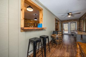 a living room with a bar and stools at Attitude Adjustment by Eden Crest in Sevierville