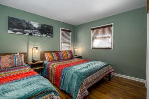 two beds in a room with green walls and windows at Attitude Adjustment by Eden Crest in Sevierville