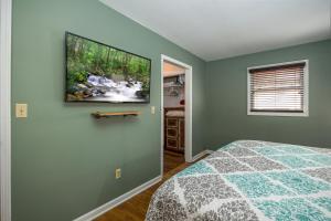 a bedroom with a bed and a tv on the wall at Attitude Adjustment by Eden Crest in Sevierville +34 photos