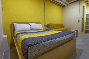 a bedroom with a bed and a yellow wall at Kali Oaxaca Hostel in Oaxaca City