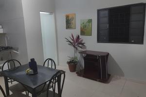a dining room with a table and a television at Apto n.08 baixo custo beneficio in Águas Claras