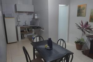 a kitchen with a black table with chairs and a dining room at Apto n.08 baixo custo beneficio in Águas Claras