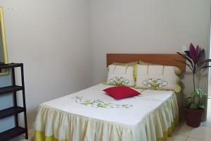 uma cama com lençóis brancos e flores em Apto baixo custo beneficio em Águas Claras