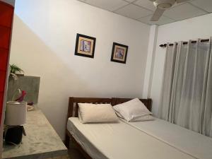 - une chambre avec 2 lits et 2 photos sur le mur dans l'établissement Suji's Villa, à Colombo