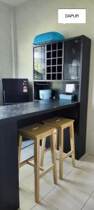 escritorio con taburete de madera y microondas en Farwis Homestay, en Mukah