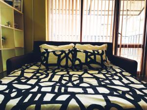 ein Bett mit einer schwarzen und weißen Bettdecke in einem Schlafzimmer in der Unterkunft Semiramida Central Studio in Warna
