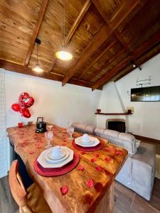 Un comedor con una mesa de madera con dos platos encima. en Recanto do Santista, chalé 02, en Camanducaia