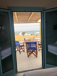 a glass door leading to a patio with a table and chairs at Studios Venetsanos in Koufonisia