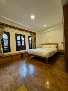 sypialnia z dużym łóżkiem i 2 oknami w obiekcie Karuna Hotel Patan Kathmandu w mieście Patan
