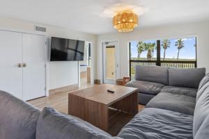 a living room with a couch and a coffee table at Saida II Beachfront Oasis in South Padre Island