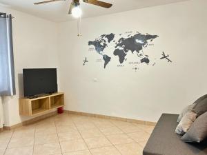 un soggiorno con TV e una mappa del mondo sul muro di Oasi sul Mare - A soli 1 Minuto a Piedi dalla Spiaggia a Senigallia