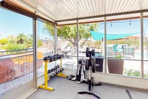 a gym with treadmills and weights in front of a window at Desert Sun Retreat in Sun City