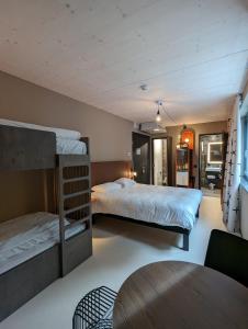 a bedroom with two bunk beds and a table at Hota Hotel Saint-Imier in Saint-Imier