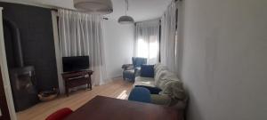 uma sala de estar com um sofá e cadeiras e uma televisão em Apartamento en el centro de Puigcerda em Puigcerdà