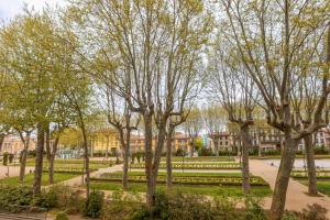 un parque con árboles frente a un edificio en L'art de Gambetta ConciergerieDameCarcas, en Carcassonne