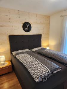 1 dormitorio con 2 camas y reloj en la pared en Haus Martina en Sand in Taufers