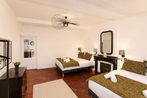 een hotelkamer met 2 bedden en een spiegel bij L'art de Gambetta ConciergerieDameCarcas in Carcassonne