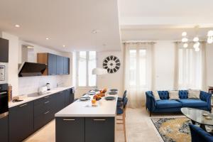 een keuken en een woonkamer met een blauwe bank bij L'art de Gambetta ConciergerieDameCarcas in Carcassonne