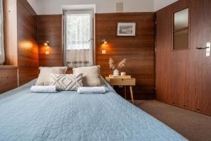 una camera da letto con un grande letto e pareti in legno di MAX Apartamenty - Pokoje - Domki - Restauracja - Basen a Mielno