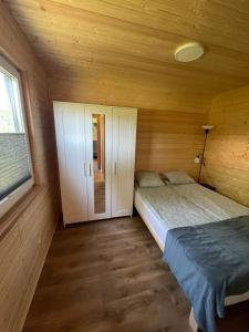 sypialnia z 2 łóżkami w drewnianym domku w obiekcie Domki letniskowe Babie Doły w mieście Gdynia
